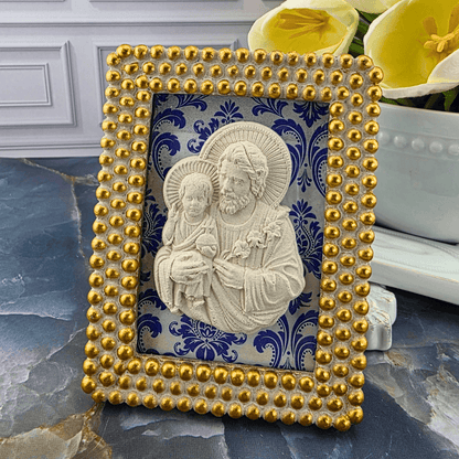 A decorative rectangular picture frame with a gold beaded border and a blue-and-white damask background, featuring a cream-colored relief of Jesus and the child. Sister Dulce Gift Shop, Shepherds Staff, Religious Store, Cypress Springs Mercedarian Prayer Center, Catholic, 