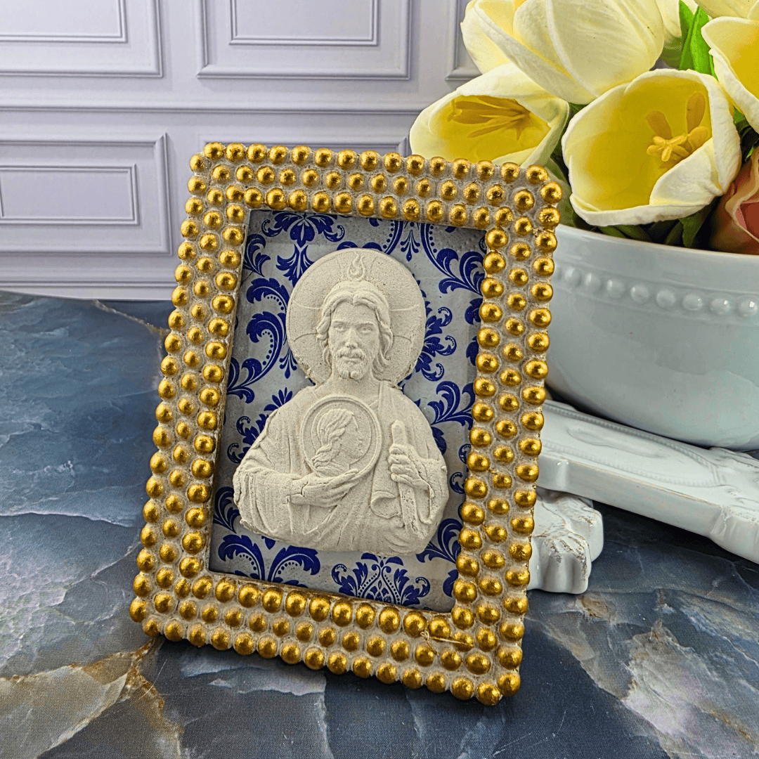 A decorative square picture frame with a gold beaded border and a white religious icon of Jesus, set against a blue and white damask pattern. Sister Dulce Gift Shop, Shepherds Staff, Religious Store, Cypress Springs Mercedarian Prayer Center, Catholic, 
