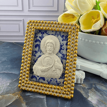 A decorative square picture frame with a gold beaded border and a white religious icon of Jesus, set against a blue and white damask pattern. Sister Dulce Gift Shop, Shepherds Staff, Religious Store, Cypress Springs Mercedarian Prayer Center, Catholic, 