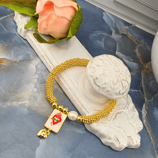 A gold beaded bracelet with a rectangular charm featuring Jesus' Sacred Heart Charm, Sister Dulce Gift Shop, Shepherds Staff, Religious Store, Cypress Springs Mercedarian Prayer Center, Catholic, harleigh leonard designs