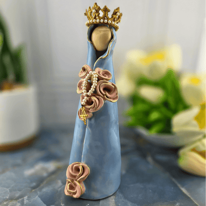 Heavenly Mother, A decorative figurine of the Virgin Mary draped in a light blue cloak, adorned with pink rose details, a pearl rosary, and a gold crown, Sister Dulce Gift Shop, Shepherds Staff, Religious Store, Cypress Springs Mercedarian Prayer Center, Catholic, 