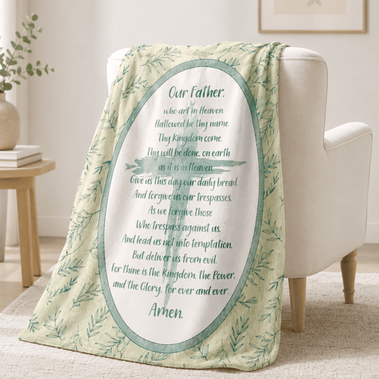 A soft throw blanket, The blanket has a pale yellow-green background with a green leafy border and a large central white oval containing the printed memorial text 'Our Father., Our Father Prayer, new item, Sister Dulce Gift Shop, Shepherds Staff, Religious Store, Cypress Springs Mercedarian Prayer Center, Catholic, 