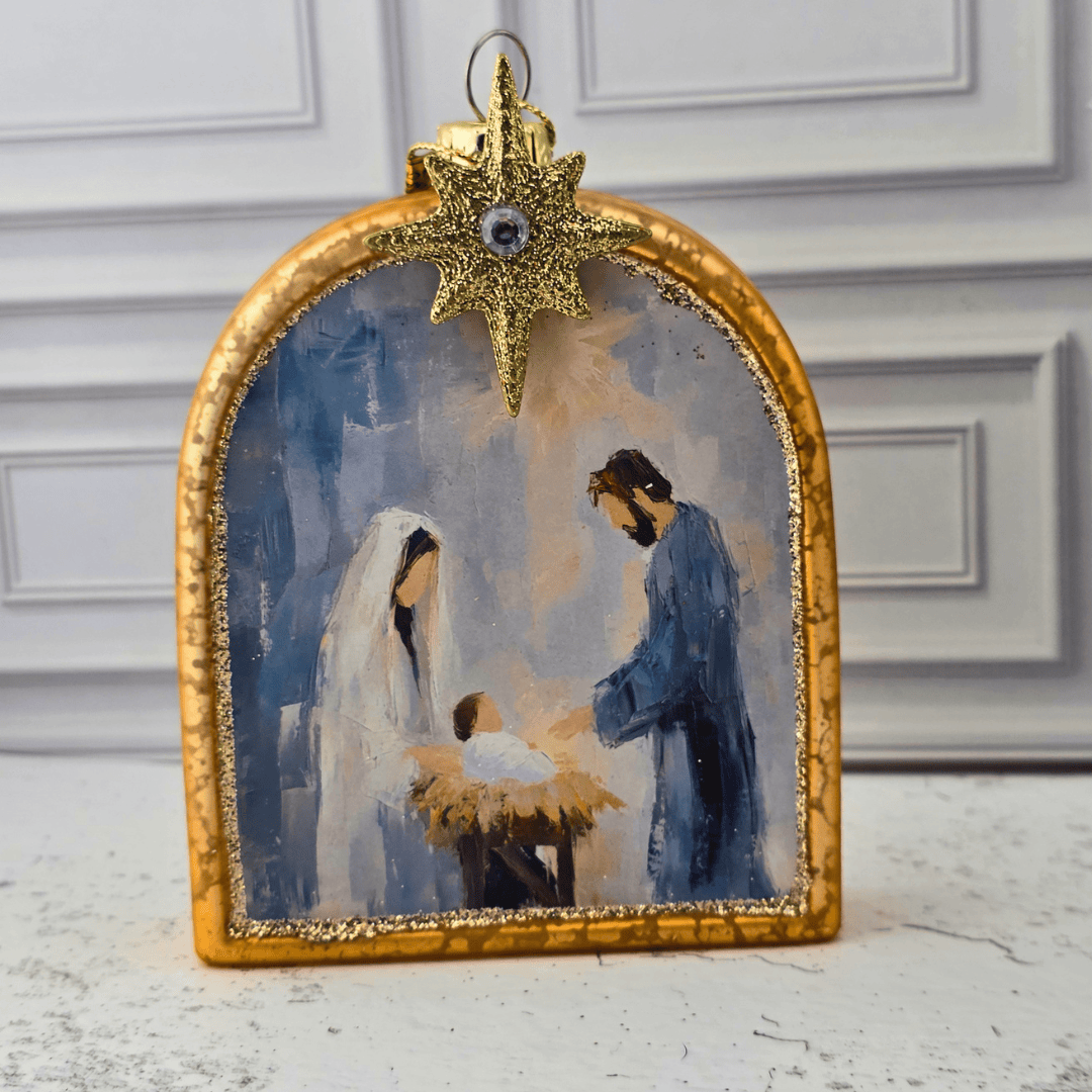 A gold-framed Christmas ornament depicting the Holy Family (Mary, Joseph, and baby Jesus) with a glittery gold star topper, Sister Dulce Gift Shop, Shepherds Staff, Religious Store, Cypress Springs Mercedarian Prayer Center, Catholic, christmas ornament, home decor