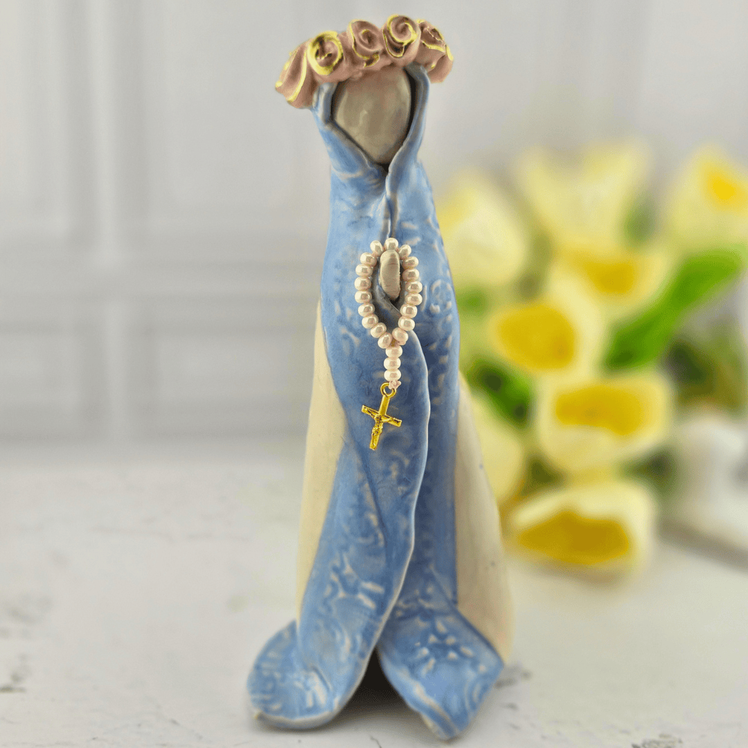 A ceramic figurine of the Virgin Mary wearing a blue and cream gown, with a pearl rosary and gold cross hanging from her hand, and a floral crown, Sister Dulce Gift Shop, Shepherds Staff, Religious Store, Cypress Springs Mercedarian Prayer Center, Catholic, new item, popular item, sacred treasures, home decor