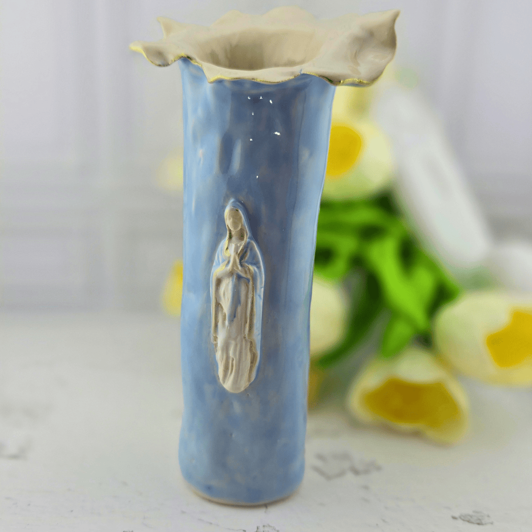 A handmade ceramic vase with a textured light blue body, featuring a raised relief of the Virgin Mary on the front and a scalloped cream-colored flared rim, Sister Dulce Gift Shop, Shepherds Staff, Religious Store, Cypress Springs Mercedarian Prayer Center, Catholic, new item, popular item, sacred treasures, home decor