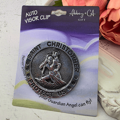 A Saint Christopher metal visor clip gift, Saint Christopher carrying the Christ child, with the words 'SAINT CHRISTOPHER PROTECT US', Sister Dulce Gift Shop, Shepherds Staff, Religious Store, Cypress Springs Mercedarian Prayer Center, Catholic, new item, gift for him, new driver, young adult