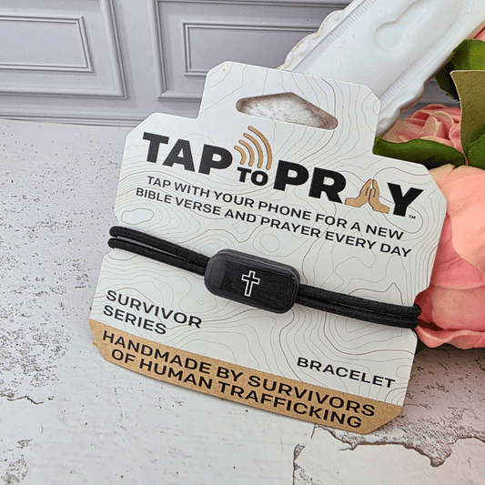A black elastic bracelet with a black cross charm, 'TAP TO PRAY' and 'SURVIVOR SERIES BRACELET', Sister Dulce Gift Shop, Shepherds Staff, Religious Store, Cypress Springs Mercedarian Prayer Center, Catholic, new item, gift for men, confirmation 