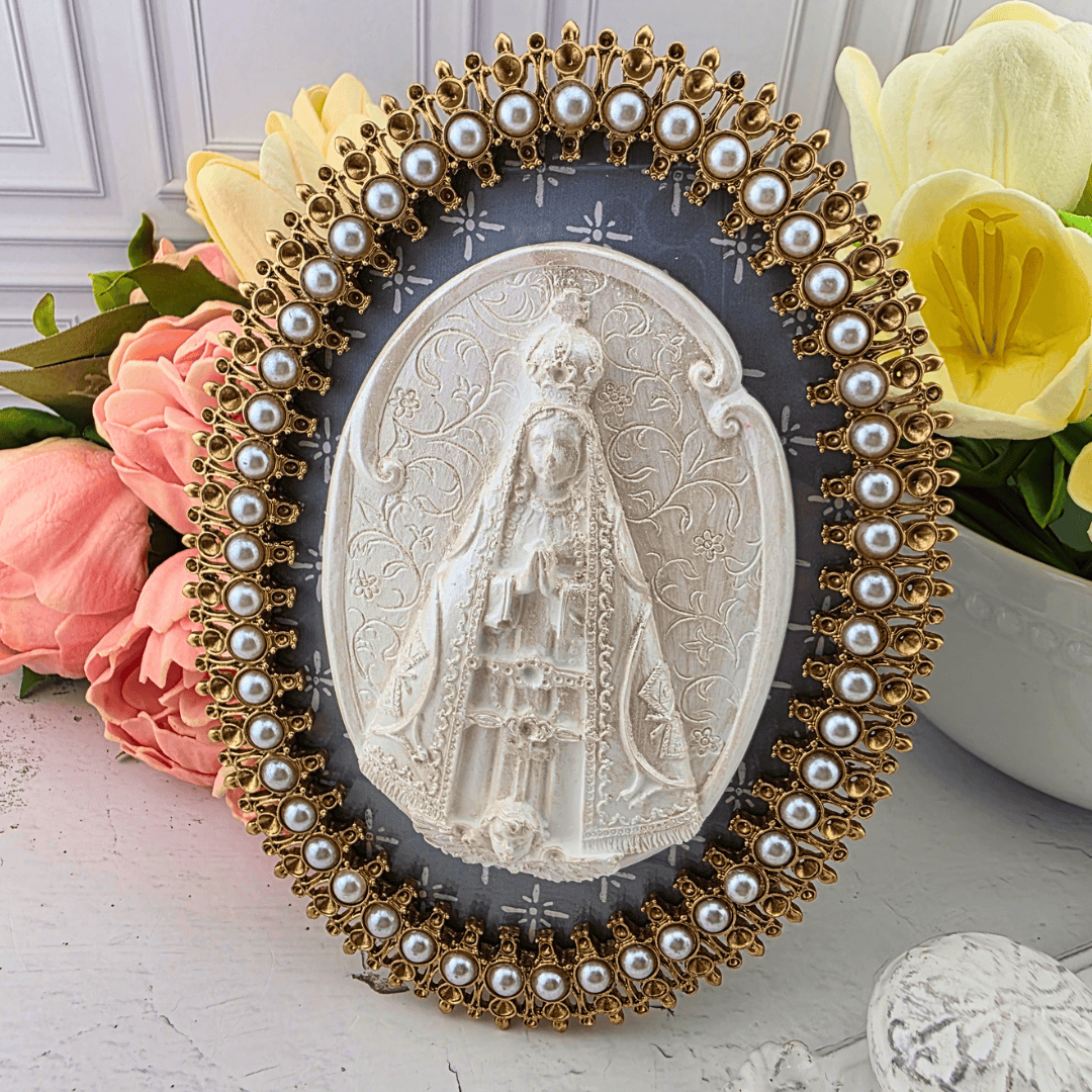 An oval religious plaque featuring a white carved depiction of the Virgin Mary, surrounded by an ornate gold-tone frame adorned with faux pearls, Sister Dulce Gift Shop, Shepherds Staff, Religious Store, Cypress Springs Mercedarian Prayer Center, Catholic, new item, popular item, home decor